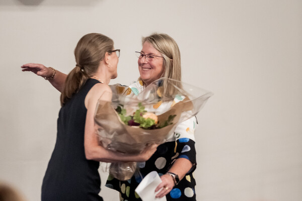 image of Barbara Gibson giving flowers to Sharon Switzer-McIntyre